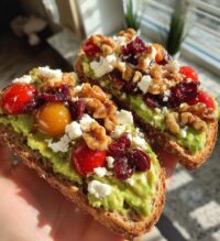 avocado toast with feta cheese cherry tomatoes cranberries and walnuts