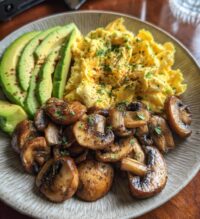keto breakfast plate with creamy scrambled eggs mushrooms avocado